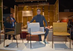 Frank van Gemert from Montis, posing with the new collection of dining chairs, Yves, featuring a distinctive steel frame. The chair has a slight hammock-like design.