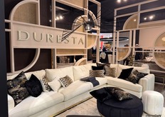 Duresta showcases a luxurious blend of white, black, and gold tones, accented with diverse cushion prints for a striking aesthetic.