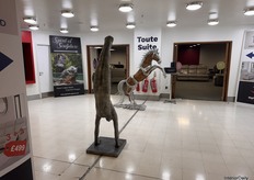 Toute Suite’s entrance showcases exquisite handcrafted metal designs, highlighted by a dynamic man doing a handstand and a powerful rearing horse.