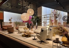 A warm, open, and spacious stand by German company Himolla, featuring a blend of warm colors and striking lighting to create a visually appealing display.