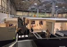 An elevated view from Hall 1 to Hall 2 via the stairs, showcasing several brands and the busy afternoon crowd.