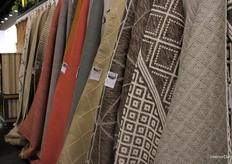 A wall filled with different fabrics, patterns, and colours at the booth of Aletco.