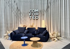 A snapshot of Comforteo’s booth, which featured a dark blue sofa at the front of the stand.