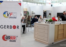 Visitors engaged in insightful conversations at Gerbor Holding’s stand, where tables created natural spaces for interaction.