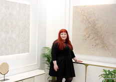 Karolina Conact in the booth of Livin Hill, posed next to her own designed wall painting.