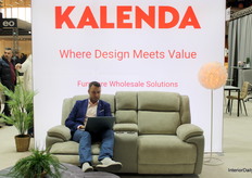 Sebastian, sales representative, engaged behind the scenes at Kalenda’s large stand, balancing work and visitor interactions.