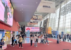 A simple glimpse of the walkways between the fair halls, with people conversing and moving from one end to the other.