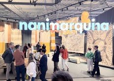 Nanimarquina's stand filled with different carpets hanging from the ceiling.