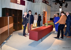 Pieter Coesel poses with his mother in the booth of the Coesel family business, with pointing father Rob on the right.